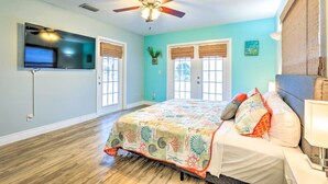 A bedroom with a bed, a ceiling fan, a TV, and a window with a view. - 'ocean Breeze Oasis' w/ Boat Dock & Slip on Canal! (Bradenton)