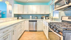 A modern kitchen with white cabinets, a stainless steel dishwasher, a gas stove, and a microwave. - 'ocean Breeze Oasis' w/ Boat Dock & Slip on Canal! (Bradenton)