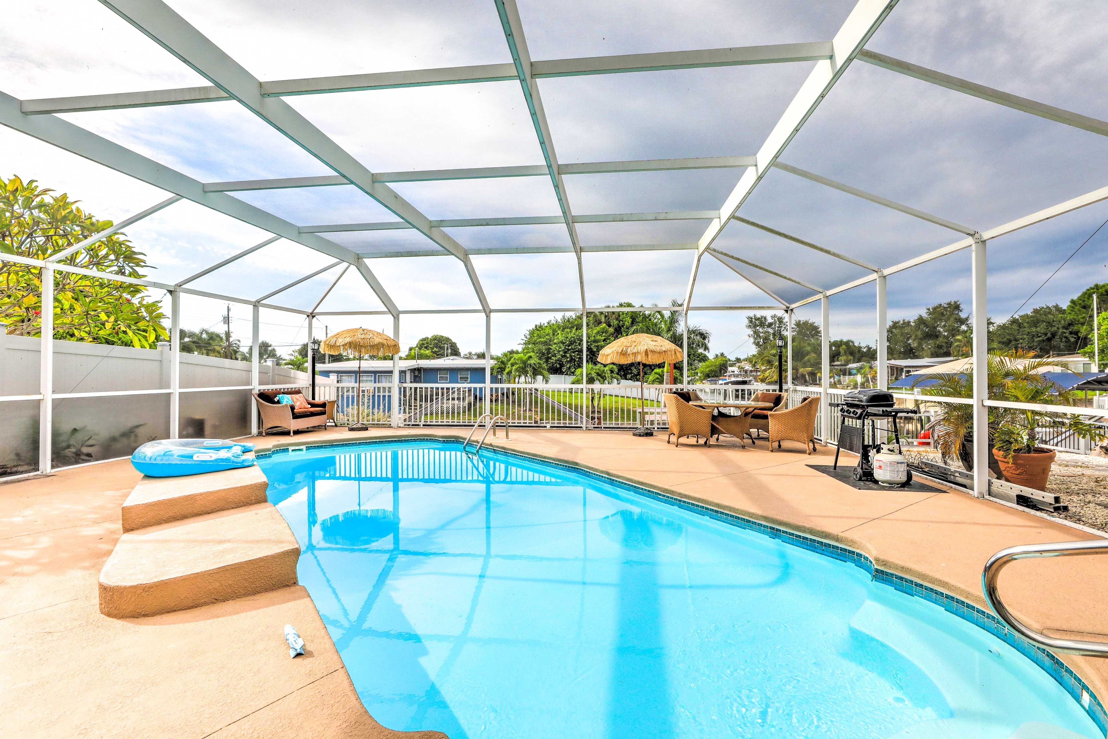 Une piscine extérieure couverte, accessible par des marches, avec des chaises longues et des parasols.