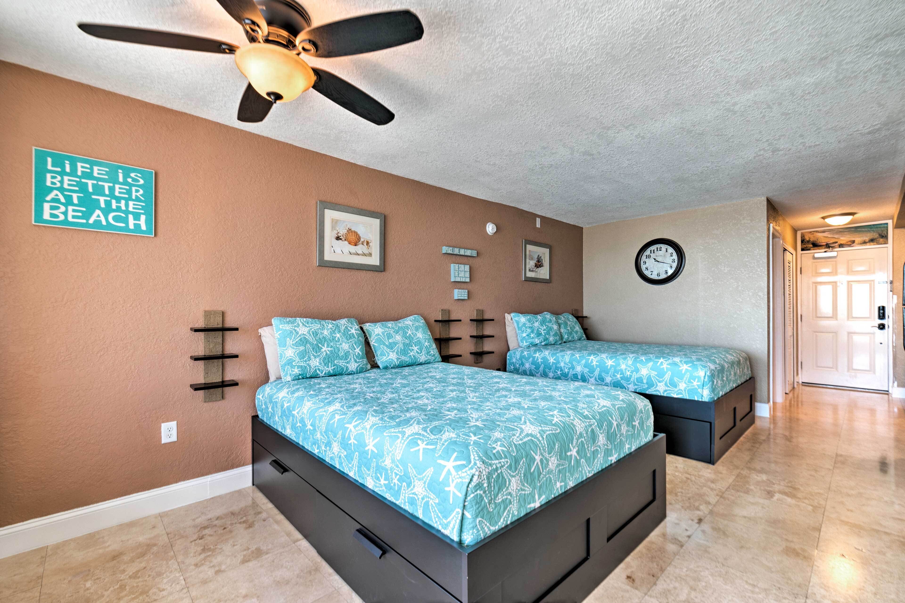 A bedroom with a bed, two bedside tables, a ceiling fan, and a clock on the wall.