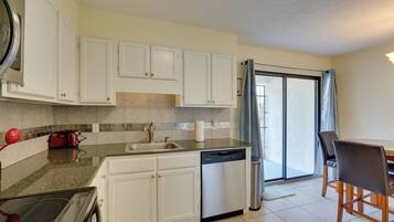 A modern kitchen with white cabinets, a dishwasher, and a red toaster.