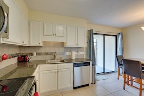 A modern kitchen with white cabinets, a dishwasher, and a red toaster. - Panama City Townhome w/ Balcony, Water Views! (Panama City)