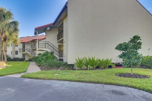 A multi-story building with a red-tiled roof, a staircase, and a well-maintained lawn with various plants. - Ocean Views + Pool Access: Tierra Verde Condo! (Tierra Verde)
