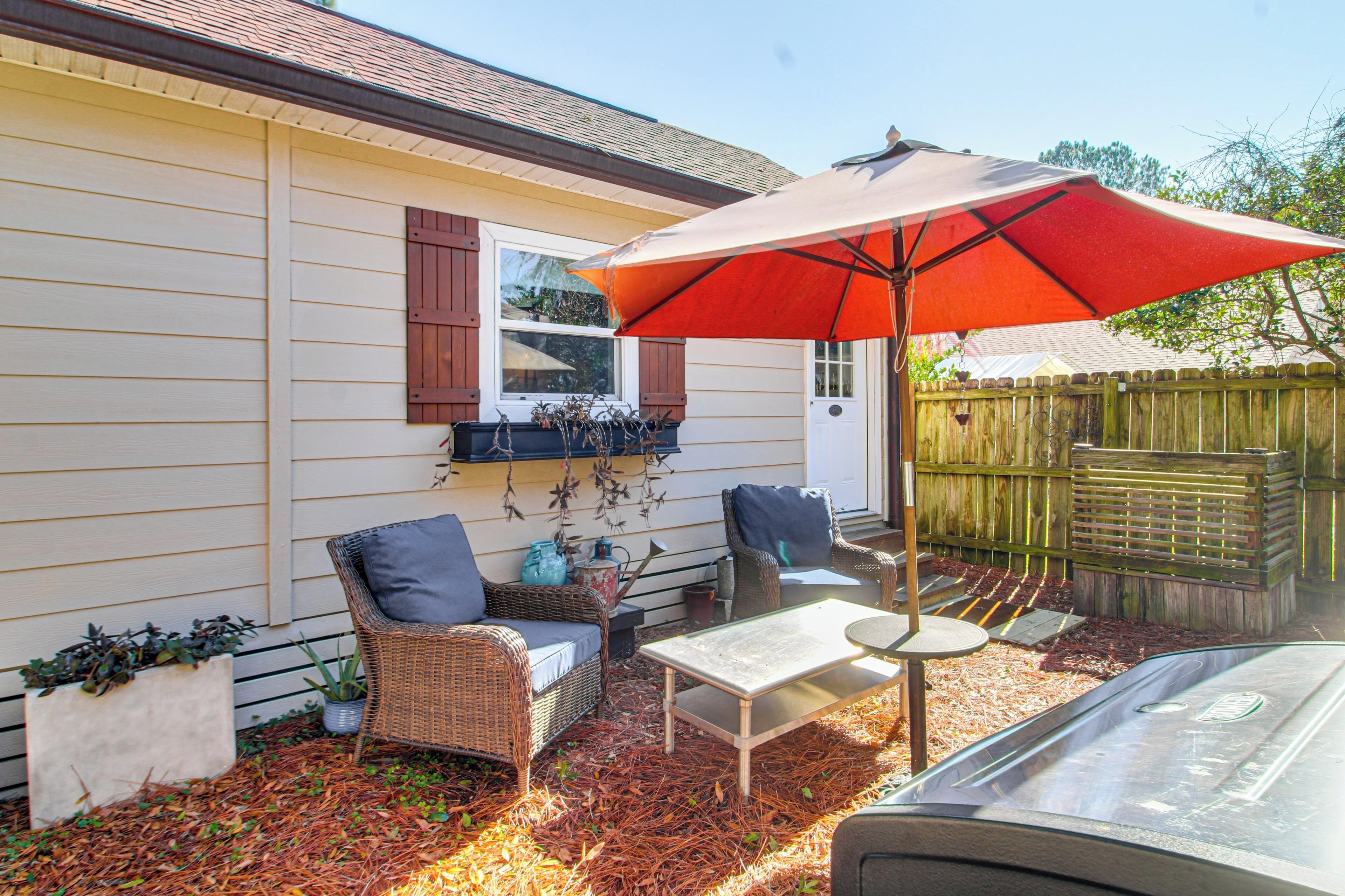 A patio area with wicker furniture, a table, and an umbrella.