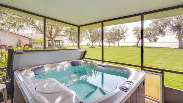 A hot tub with a view of a grassy area and trees. - Cozy Frostproof Escape w/ Private Hot Tub! (Frostproof)