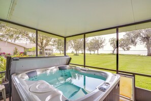 A hot tub with a view of a grassy area and trees. - Cozy Frostproof Escape w/ Private Hot Tub! (Frostproof)
