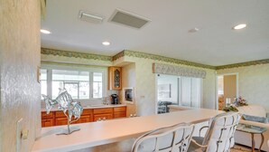 A spacious kitchen with a large island, wooden cabinets, and a decorative fish sculpture. - Cozy Frostproof Escape w/ Private Hot Tub! (Frostproof)