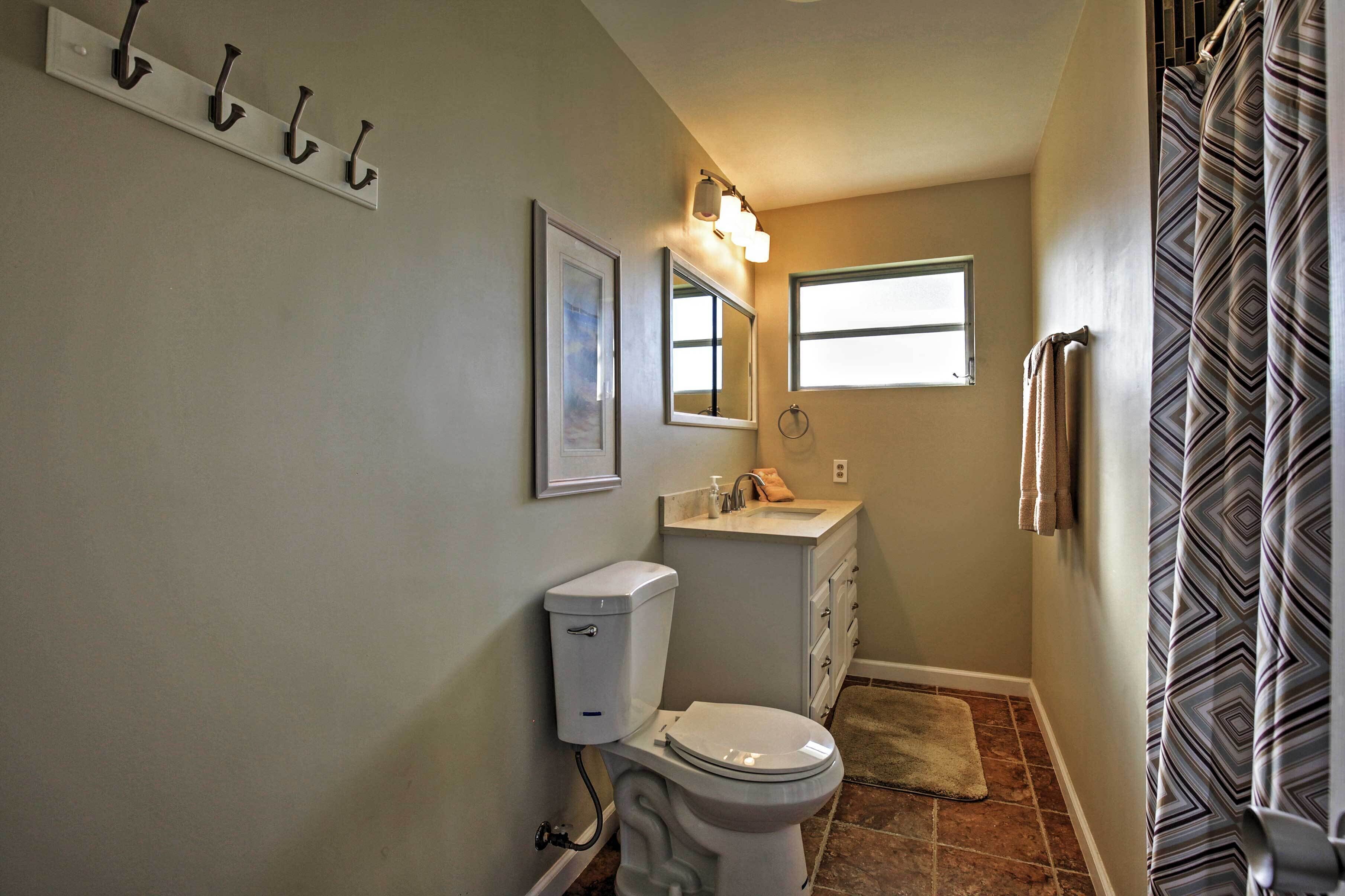 A compact bathroom with a toilet, sink, and a window providing natural light.