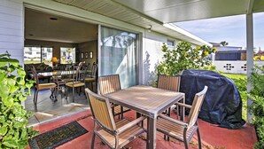 An outdoor patio with a wooden table and chairs, a covered grill, and a view of the backyard. - Pet-friendly Daytona Beach Home, Walk to the Ocean (Port Orange)