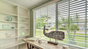 A room with a desk, shelves, and a window with blinds. - Punta Gorda Retreat Near Historic Downtown! (Punta Gorda)