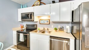 A modern kitchen with white cabinets, stainless steel appliances, and a dishwasher. - Pet-friendly PCB Duplex - Walk to Beach! (Panama City Beach)
