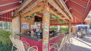 A tiki bar with a wooden structure, a counter, and bar stools. - Private Pool + Game Room! Davenport Family Home (Davenport)