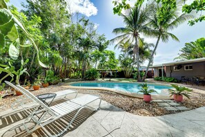 A swimming pool surrounded by tropical plants and a patio area with lounge chairs. - Oakland Park Vacation Rental w/ Private Pool! (Oakland Park)