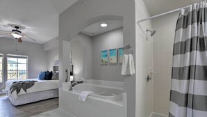 Un baño moderno con bañera, ducha y ventilador de techo.