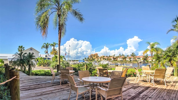 A wooden deck with outdoor seating and a view of a marina. - Resort-style Condo w/ Pool: 19 Miles to Fort Myers (Punta Gorda)
