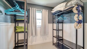 Ein Zimmer mit Etagenbetten, einem Wäscheständer und einem Vorhang.