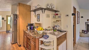 A kitchen with wooden cabinets, a granite countertop, a built-in oven, and a stainless steel refrigerator. - Quincy Home w/ Deck & Outdoor Patio Furniture (Quincy)