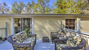 A covered outdoor deck with wicker furniture and a small table. - Quincy Home w/ Deck & Outdoor Patio Furniture (Quincy)