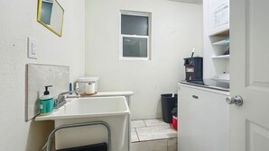 A small, clean bathroom with a white sink, a mirror, a window, and a toilet. - Dock & Kayaks: Riverfront Dunnellon Home! (Dunnellon)