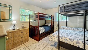 A bunk bed room with a wooden bunk bed, a single bed, a dresser, and a ceiling fan. - Dock & Kayaks: Riverfront Dunnellon Home! (Dunnellon)