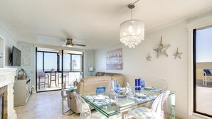 A dining area with a glass table and chairs, a chandelier, and star decorations on the wall. - Resort-style Penthouse w/ Patio in Hudson! (Hudson)