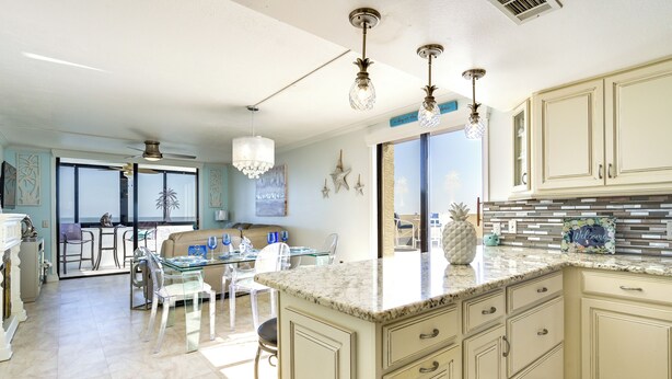A spacious kitchen with a large island, light-colored cabinetry, and a view to the outside. - Resort-style Penthouse w/ Patio in Hudson! (Hudson)