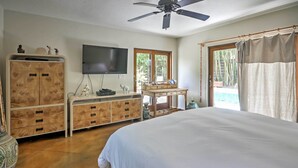 A bedroom with a large bed, wooden wardrobe, a flat-screen TV, and a desk with a chair. - Sarasota House w/ Backyard Oasis: 6 Mi to Beach! (Sarasota)