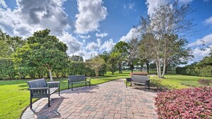 A paved walkway with benches and lush greenery. - 10 Mi to Disney + Heated Pool: Florida Abode! (Clermont)