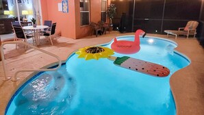 An indoor swimming pool with a pink flamingo float and a sun-shaped float. - 10 Mi to Disney + Heated Pool: Florida Abode! (Clermont)