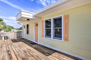 A house with a wooden deck, a covered porch, and a light green exterior. - Siesta Key Village Home < Half Mi to Beach! (Siesta Key)