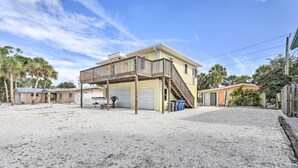 A two-story house with a balcony, a garage, and a gravel driveway. - Siesta Key Village Home < Half Mi to Beach! (Siesta Key)
