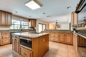 A spacious kitchen with a large island, wooden cabinetry, and a built-in oven. - Spacious Tampa Vacation Rental w/ Pool & Dock (Tampa)
