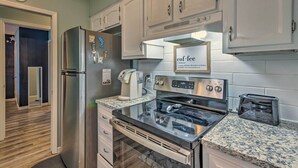 A modern kitchen with stainless steel appliances, granite countertops, and white cabinetry. - Stellar Fort Walton Retreat ~ 2 Mi to Beach! (Fort Walton Beach)