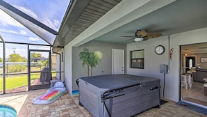 A covered outdoor area with a pool, a hot tub, and a large inflatable mattress. - Stunning Cape Coral Home w/ Open Floor Plan! (Cape Coral)
