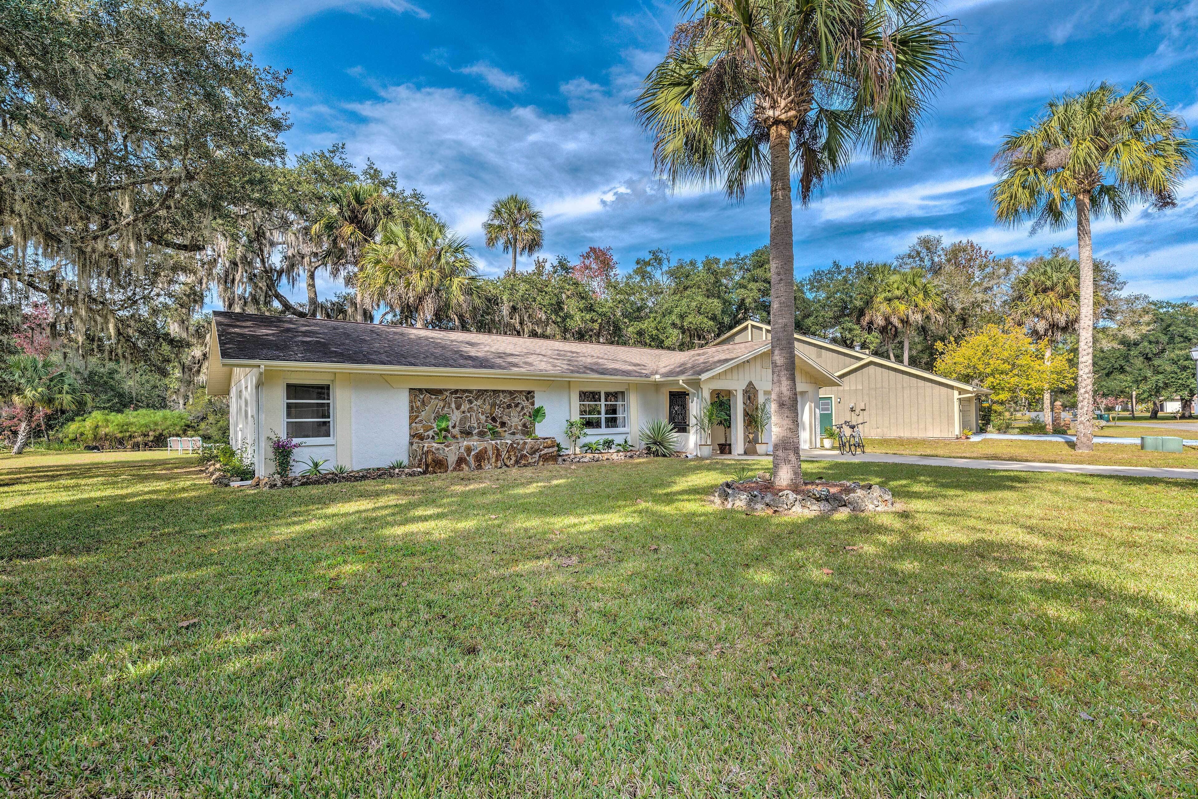 A single-story house with a stone foundation, a front porch, and a well-maintained lawn.
