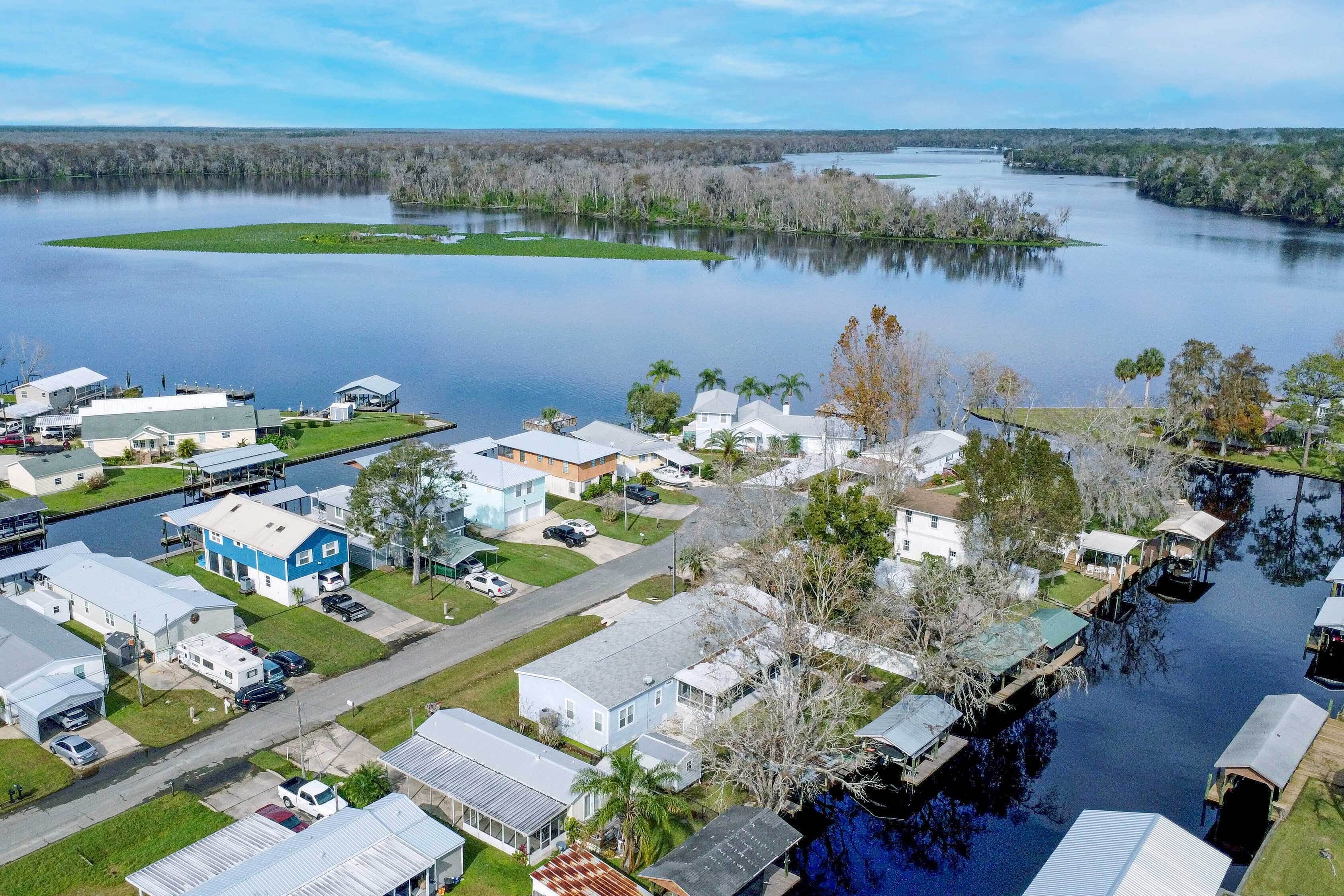 A residential area with houses and docks along a calm lake.