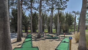 A miniature golf course with numbered holes, surrounded by tall trees. - Kissimmee Resort Townhome w/ Pool, 7 Mi to Disney! (Kissimmee)