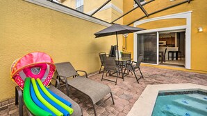 A patio with a pool, outdoor seating, and a dining area. - Kissimmee Resort Townhome w/ Pool, 7 Mi to Disney! (Kissimmee)