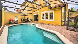 A swimming pool with a covered patio area, a yellow building, and a brick pathway. - Kissimmee Resort Townhome w/ Pool, 7 Mi to Disney! (Kissimmee)