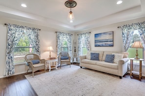 A living room with a sofa, chairs, a rug, and curtains. - Fairways & MLB Fun! Poolside Haven in Lehigh Acres (Lehigh Acres)