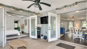 A spacious room with a bed, a dining area, and a kitchen.