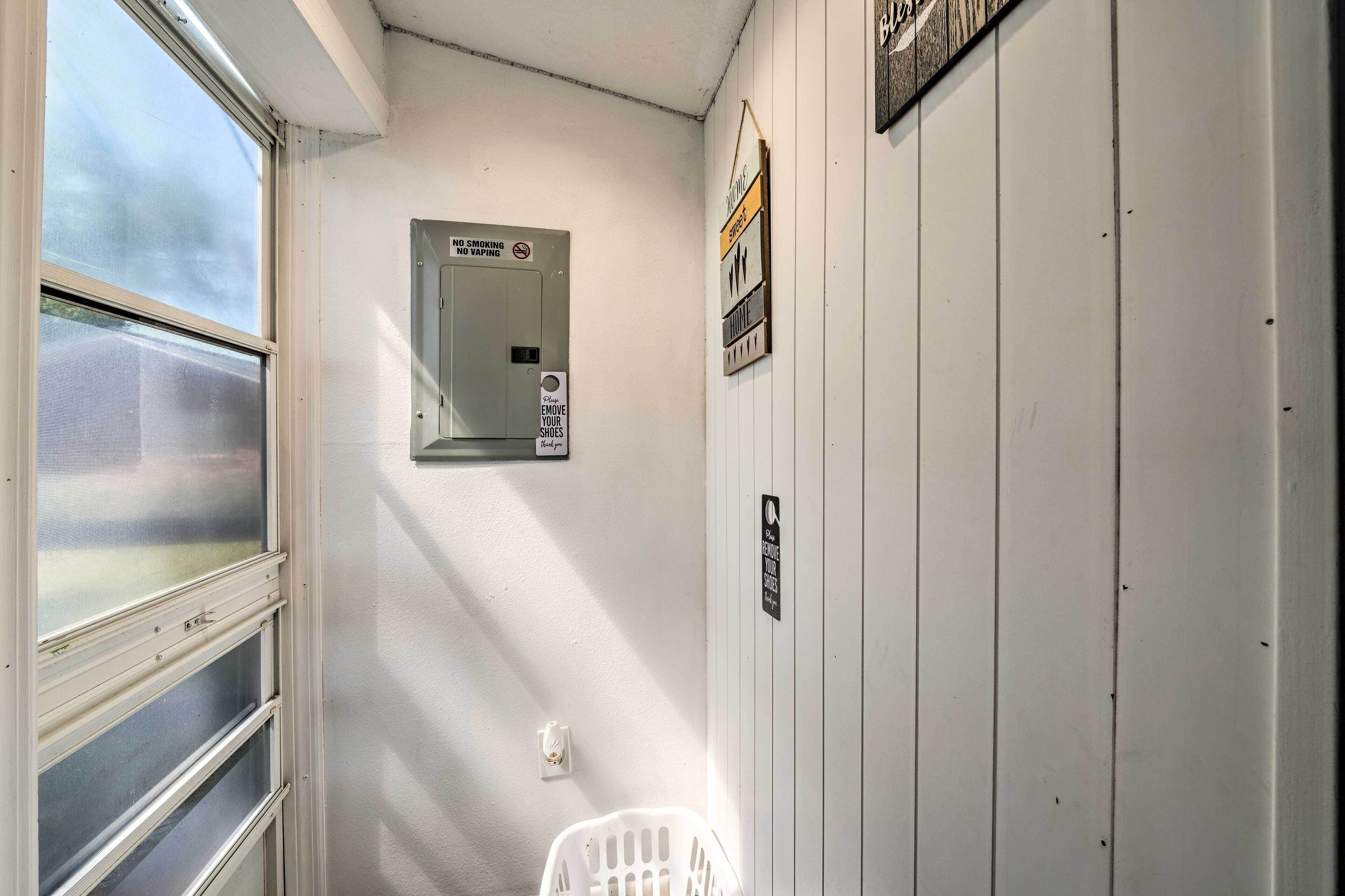 A narrow hallway with a window on the left, a door with a 'No Smoking' sign, and a wall-mounted light switch.