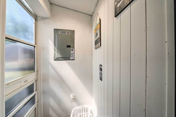 A narrow hallway with a window on the left, a door with a 'No Smoking' sign, and a wall-mounted light switch.