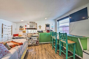 Une cuisine compacte équipée d’un évier, d’une cuisinière et d’un petit coin repas avec des chaises.