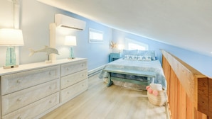 A bedroom with a bed, dresser, nightstands, and a starfish decoration. - Tropical Cottage < 2 Mi to Hobe Sound Beach! (Hobe Sound)
