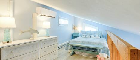 Une chambre à coucher comprenant un lit, une commode, des tables de chevet et une décoration en forme d’étoile de mer.