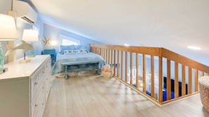 A bedroom with a bed, bedside lamps, a dresser, a window, and a view of the outside. - Tropical Cottage < 2 Mi to Hobe Sound Beach! (Hobe Sound)