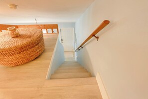 A wooden staircase with a woven ottoman and a wooden handrail. - Tropical Cottage < 2 Mi to Hobe Sound Beach! (Hobe Sound)