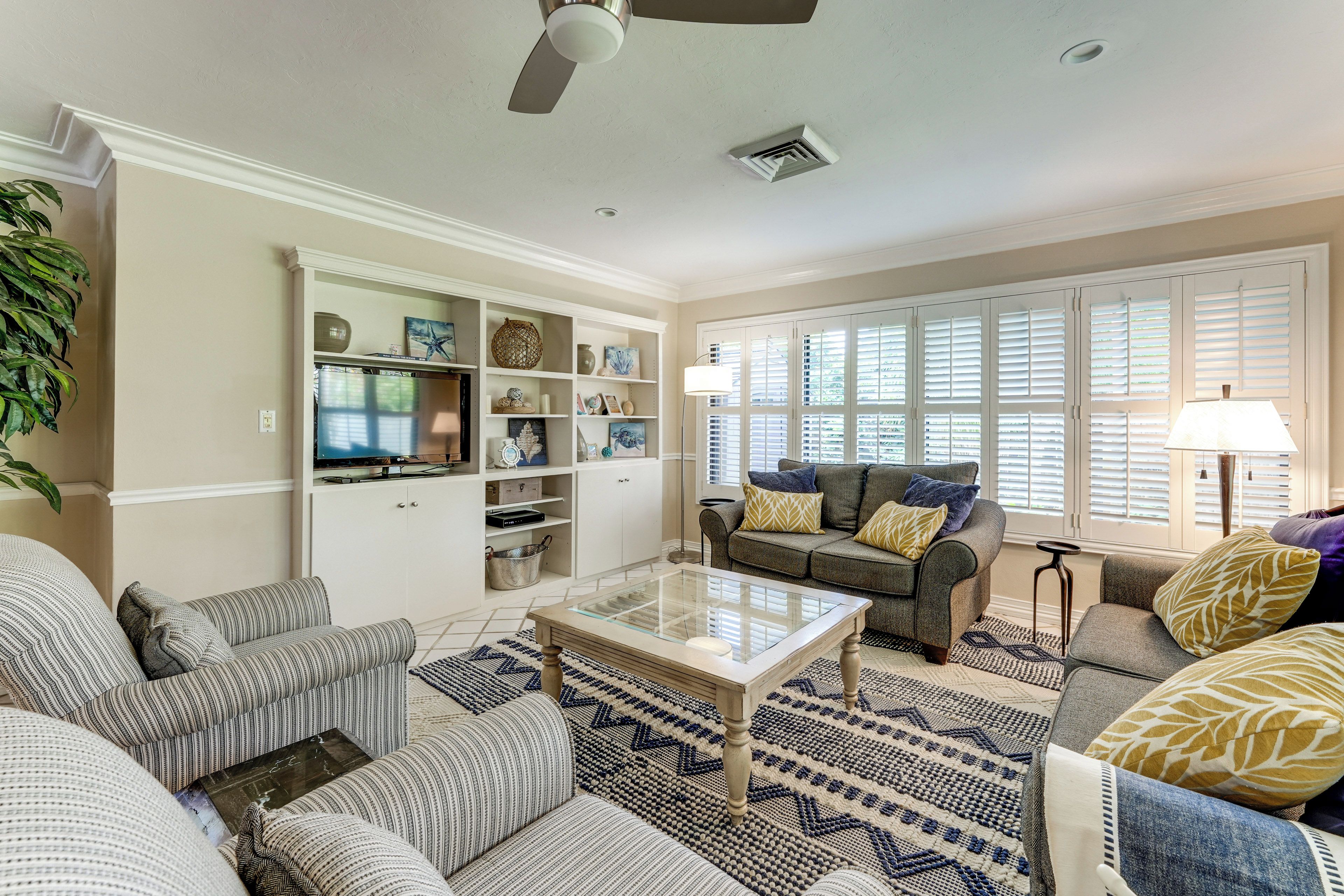 A living room with a sofa set, a coffee table, and a television on a cabinet.