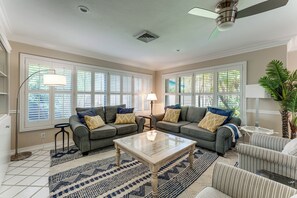 A spacious living room with a large sofa set, a coffee table, and a ceiling fan. - 2 Mi to Beach! Oakland Park Home w/ Outdoor Oasis (Oakland Park)